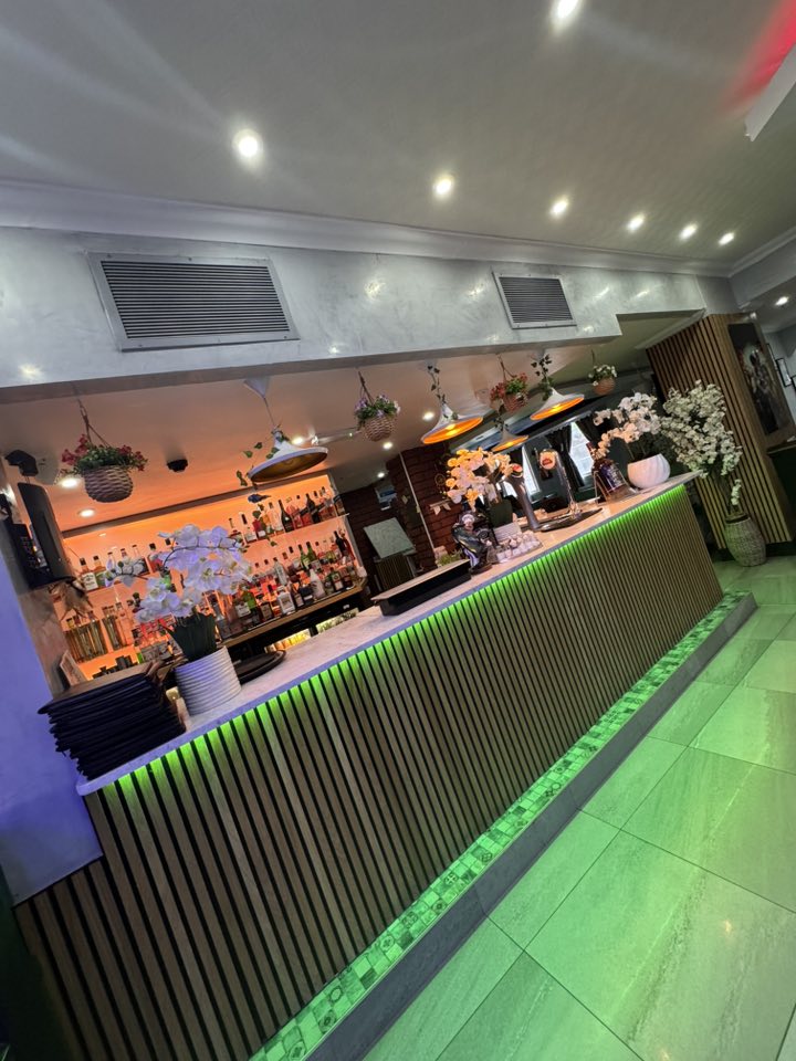 Bacaba Restaurant Oldbury, bar area with green-lit slatted panel and bottles display