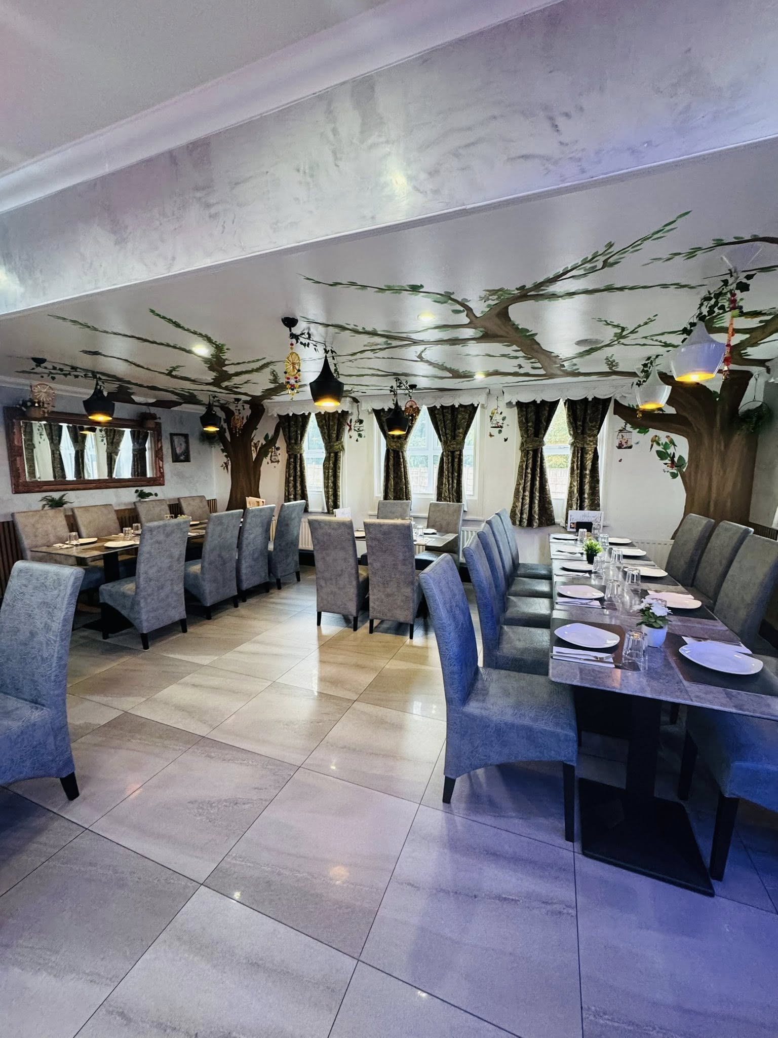 Inside Bacaba Restaurant, tree mural dining room with lantern-style lights